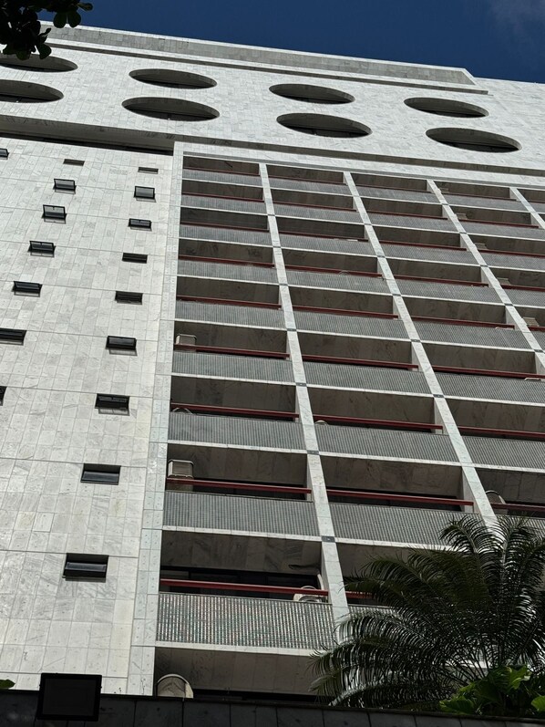A high-rise building with a grid of windows and balconies. - FLAT RECIFE BOA VIAGEM (Recife)