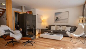 Un salon avec une cheminée, un canapé, une table basse et un fauteuil.
