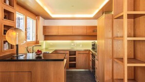 Une cuisine moderne avec des meubles en bois, un îlot central et un luminaire suspendu.