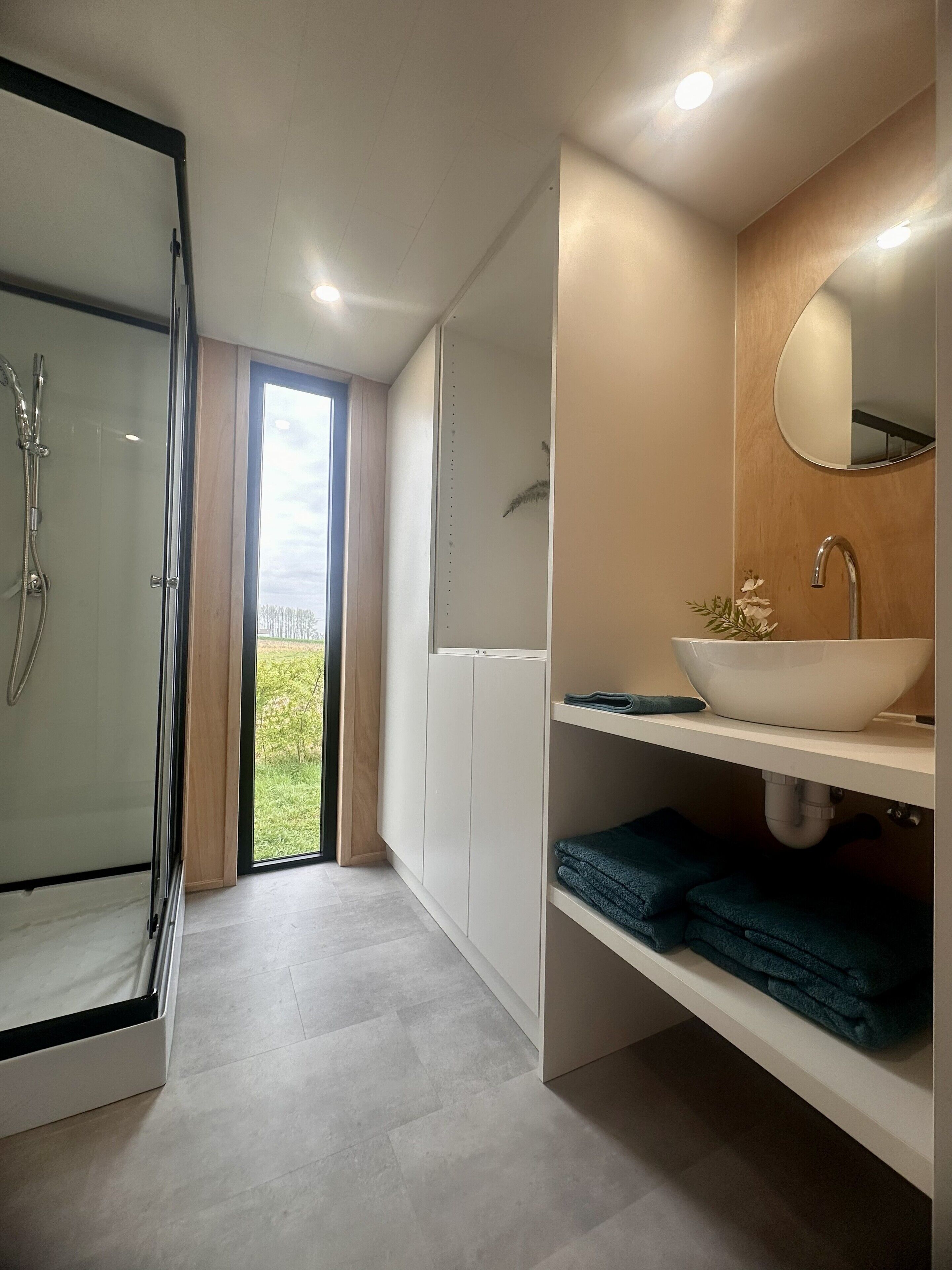 Een douche, handdoeken, zeep, toiletpapier