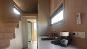 A modern kitchen with a coffee machine, a window, and a view of the outdoors. - Tiny House by Gad Bourgeois "La parenthèse nature" 8km from Pairi Daiza (Chièvres)