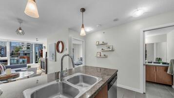 A modern kitchen with a double sink, granite countertop, and pendant lighting.