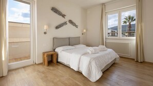 A bedroom with a bed, bedside tables, a window with a view, and wall art. - Apartment 'Don Onofrio - Lavinia' with Mountain View, Wi-Fi and Air Conditioning (Monopoli)