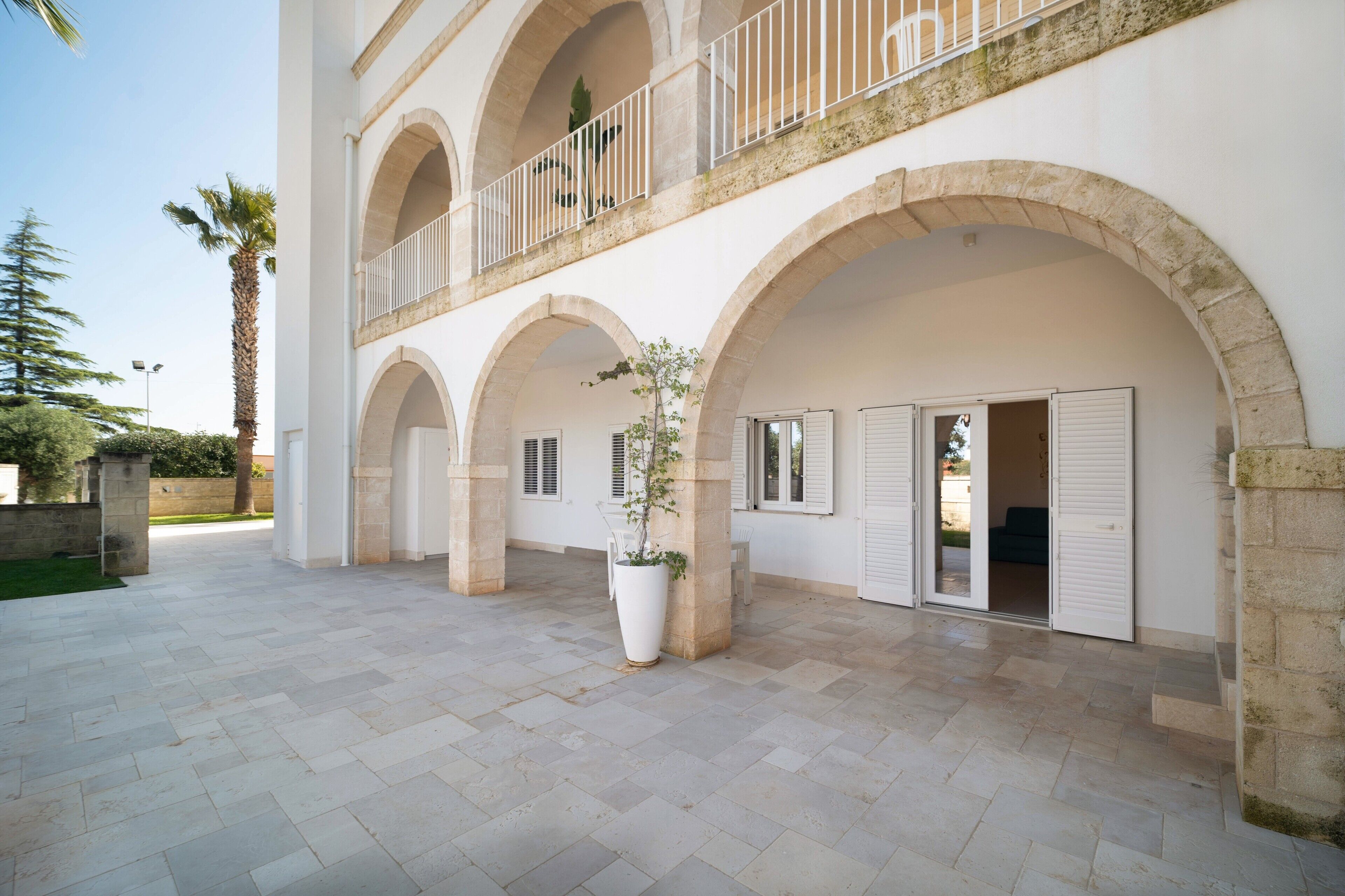 Un bâtiment doté d’une cour intérieure, d’arcs en pierre et d’un balcon avec des balustrades blanches.