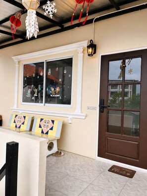 Una habitación con una ventana decorada con copos de nieve y un banco con baldosas de colores.