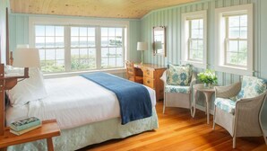 Une chambre à coucher avec un lit, un bureau, une chaise et une vue sur l’extérieur.