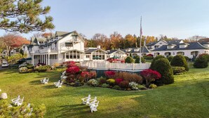 Un grand hôtel à plusieurs étages, doté d’une pelouse bien entretenue et d’un espace extérieur aménagé avec des sièges.