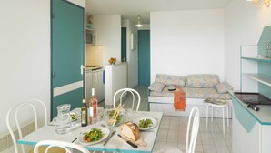 A compact living space with a dining area, kitchenette, and a sofa. - Spacious Coastal Stay for 8 in Cap D'agde (Agde)