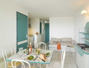 A compact living space with a dining area, kitchenette, and a sofa. - Spacious Coastal Stay for 8 in Cap D'agde (Agde)