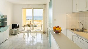 A modern kitchen with a dining area, a view of the sea, and a balcony. - Spacious Coastal Stay for 8 in Cap D'agde (Agde)