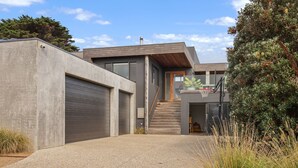A modern house with a concrete facade, a wooden staircase, and a basketball hoop. - Surfers Rest in Surf Beach (Surf Beach)