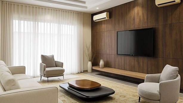 A modern living room with a large flat-screen TV mounted on a wooden wall, a sofa set, and a decorative bowl on a rug.