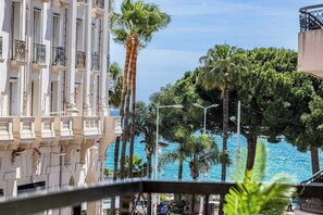 A building with balconies, palm trees, and a view of the sea. - Modern Appartement a/c 2br/4p - Cannes (Cannes)