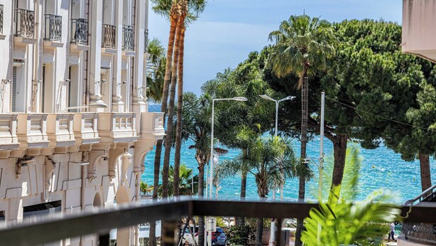 A building with balconies, palm trees, and a view of the sea. - Modern Appartement a/c 2br/4p - Cannes (Cannes)