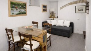Un espacio habitable compacto con una mesa de comedor, sillas, un sofá y una lámpara.
