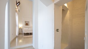 A narrow hallway with a staircase leading to a room with a bed and a shelf with a vase. - Apartment in 'Dimora S' Hotel with Private Terrace, Wi-Fi, and Air Conditioning (Sogliano Cavour)