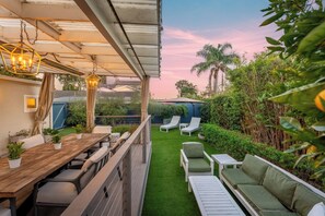 A rooftop terrace with a wooden table, chairs, a sofa, and lounge chairs. - Casa Alma del Mar | Hot Tub + Walk to Beach (Santa Barbara)