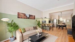 A living room with a sofa, coffee table, and a dining area with chairs and a table. - Super central, 2 bedrooms (Berlin)
