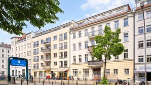 A multi-story building with a sign for Bernauer Straße, balconies, and bicycles parked outside. - Super central, 2 bedrooms (Berlin)