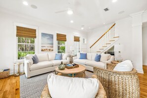 A spacious living room with a white sofa set, a coffee table, and a wicker chair. - Watersound Home w/ LSV and Community Pool (Watersound)