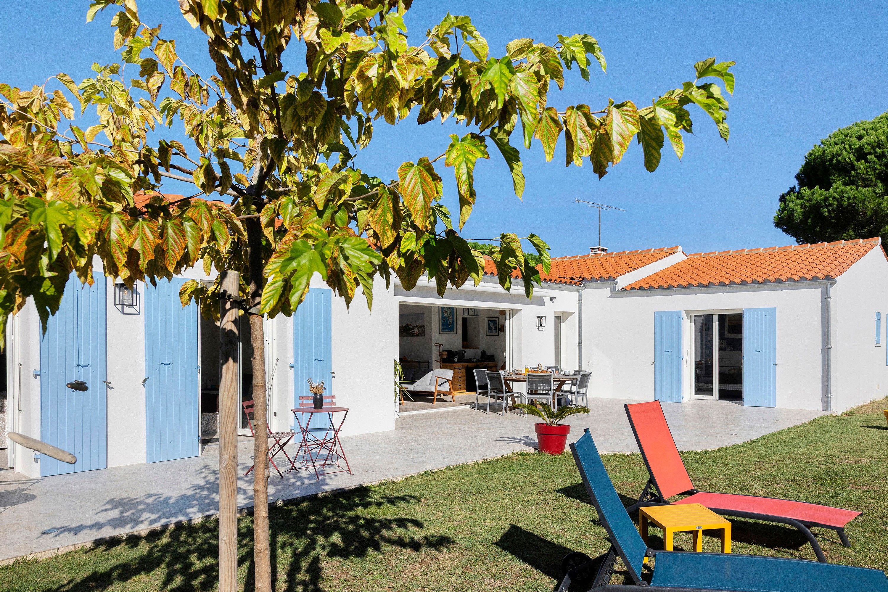 Propiedad residencial con patio, mobiliario exterior y cocina visible.