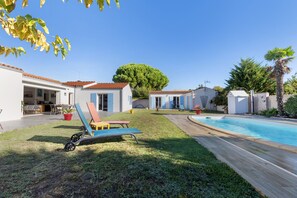 A residential property with a swimming pool, a covered patio area, and a well-maintained lawn. - Bed and Breakfast 'Suite Les Plages' with Shared Pool, Shared Garden and Wi-Fi (La Brée-les-Bains)