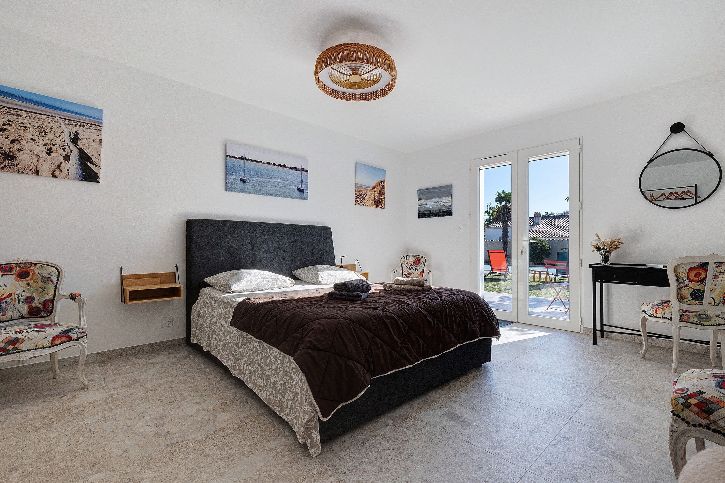 Un dormitorio con cama, una silla, un escritorio y ventana.