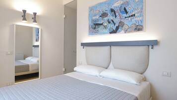Ein Schlafzimmer mit Bett, Kopfteil, Wandbild und Spiegel.