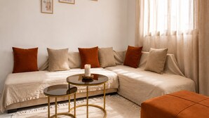 A modern bedroom with a bed, two round tables, and a sofa. - Sandra 28 (Tunis)