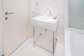 A bathroom with a white sink, chrome faucet, and a mirror above it. - National Street Residence 1bbknsinternet (Antwerp)