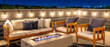 Un espacio al aire libre con sofás, sillas y una chimenea.
