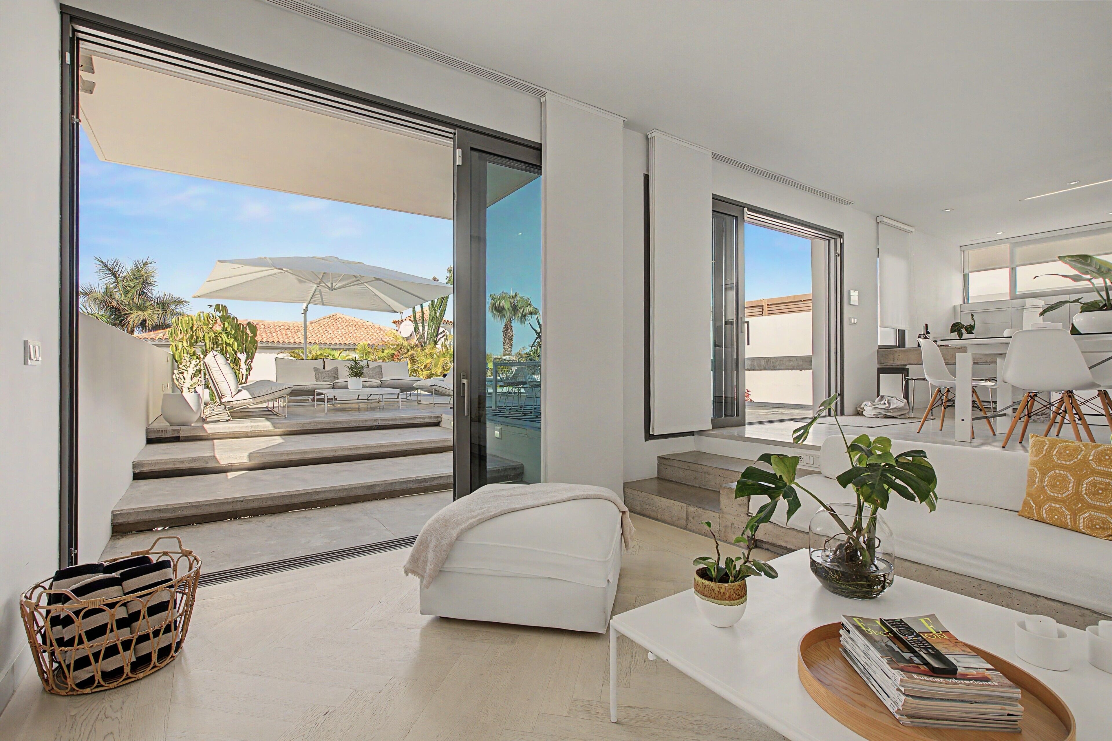 Una sala moderna con sofá, mesa de centro y vista al patio exterior.