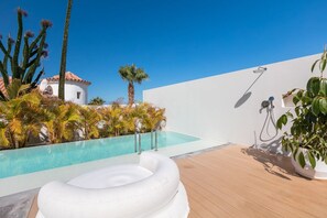 A pool area with a hot tub, palm trees, and a white building. - Vacation Villa 'Esperanza' with Sea View, Wi-Fi and Air Conditioning (Costa Adeje)