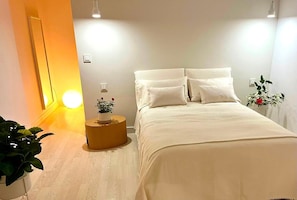 A bedroom with a bed, bedside table, and a mirror. - Vacation Villa 'Esperanza' with Sea View, Wi-Fi and Air Conditioning (Costa Adeje)