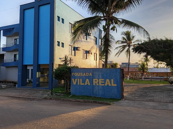 Un edificio moderno con un letrero que dice 'POUSADA VILA REAL'.