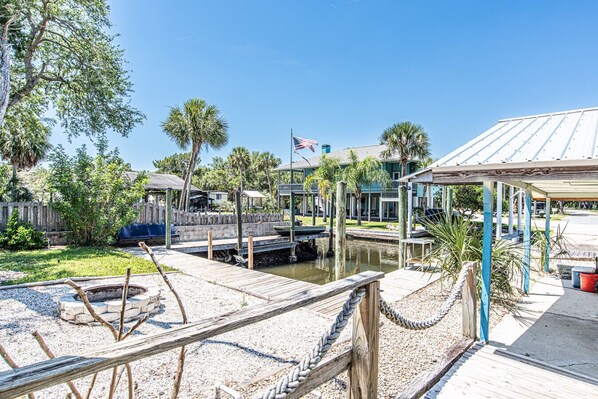 A dock area with boats, a flag, and a building with a blue roof.
