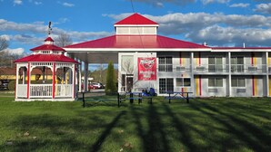 A building with a red roof, a gazebo, and a banner reading 'Mustang Hall'. - Saffron Inn (Auburn)