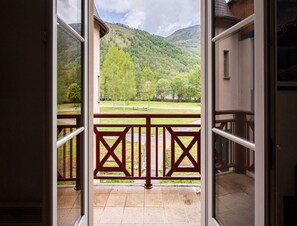 Un balcón con vistas a un paisaje verde y colinas.