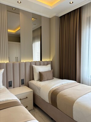 Une chambre moderne avec un grand lit, des tables de chevet, une armoire et un miroir.