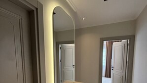 A hallway with a vanity, a mirror, and a door leading to another room. - Luxury apartment in Alanya with 270° panoramic views & only 5 min to the beach (Kargicak)