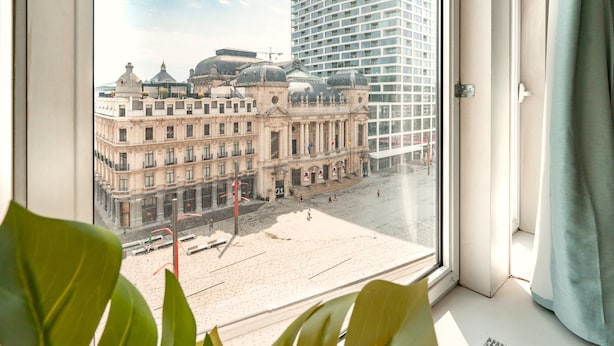 A view from a window overlooking a plaza with historic buildings and a modern skyscraper. - Deluxe 7-guest Apartment in Antwerp (Antwerp)