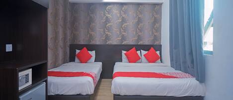 Habitación de hotel con dos camas, un minibar, una lámpara de techo y una ventana con cortinas.