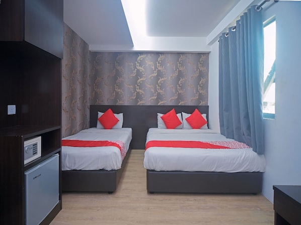 Habitación de hotel con dos camas, un minibar, una lámpara de techo y una ventana con cortinas.