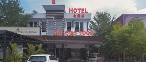 Un hotel con un cartel grande con el número 7, un número de contacto y un cartel que dice 'MASI AYAM De AROMA'.