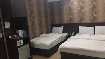 Habitación de hotel con dos camas, un escritorio pequeño y un minibar.