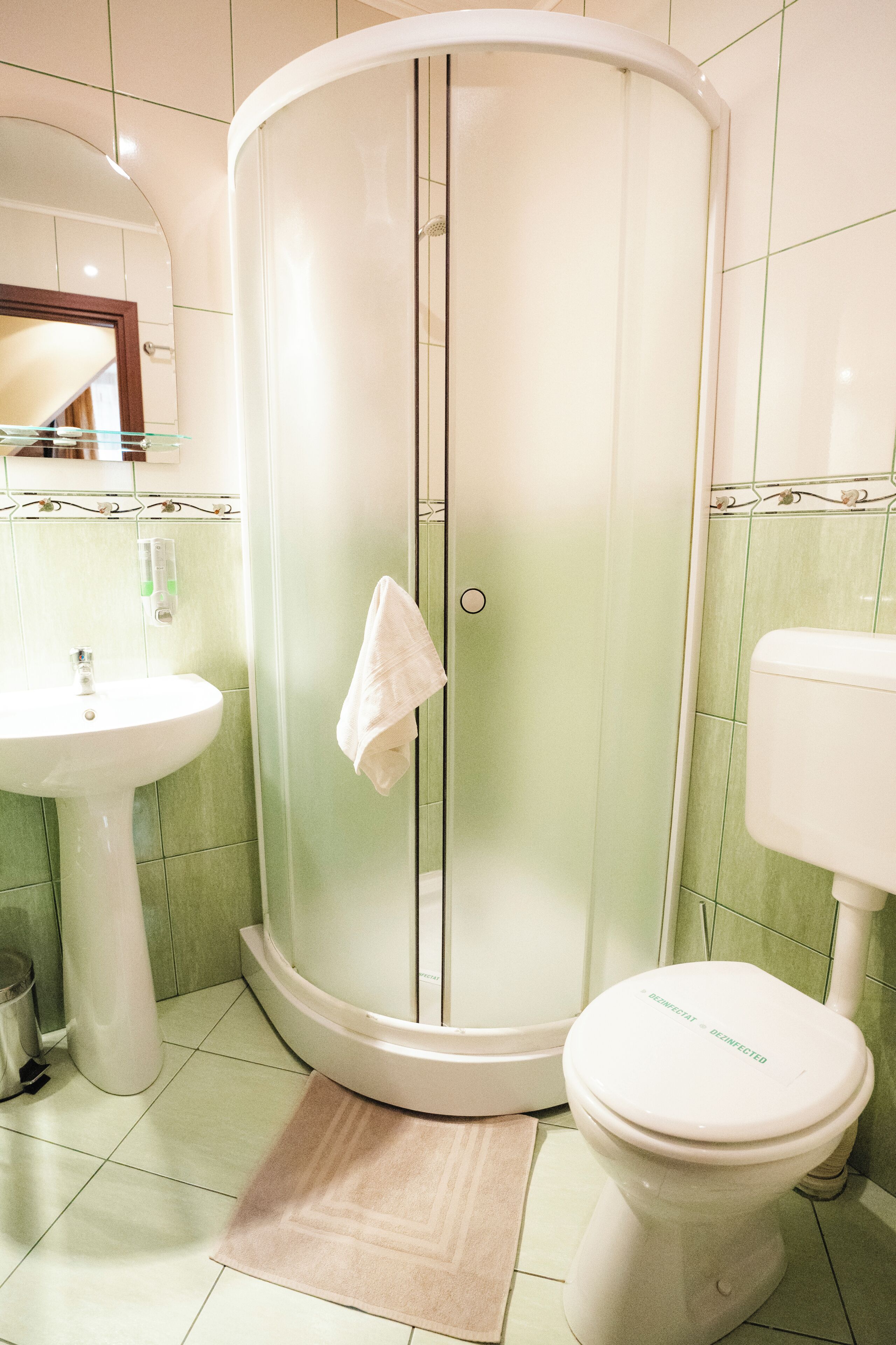 A bathroom with a glass-enclosed shower, a sink, and a toilet.