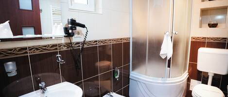 Une salle de bain équipée d’un lavabo, d’un bidet, de toilettes et d’un espace douche.