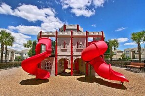 A playground with red slides and a castle-like structure. - Windsor Hills 4BR Single-Level Pool Home,By Disney (Kissimmee)