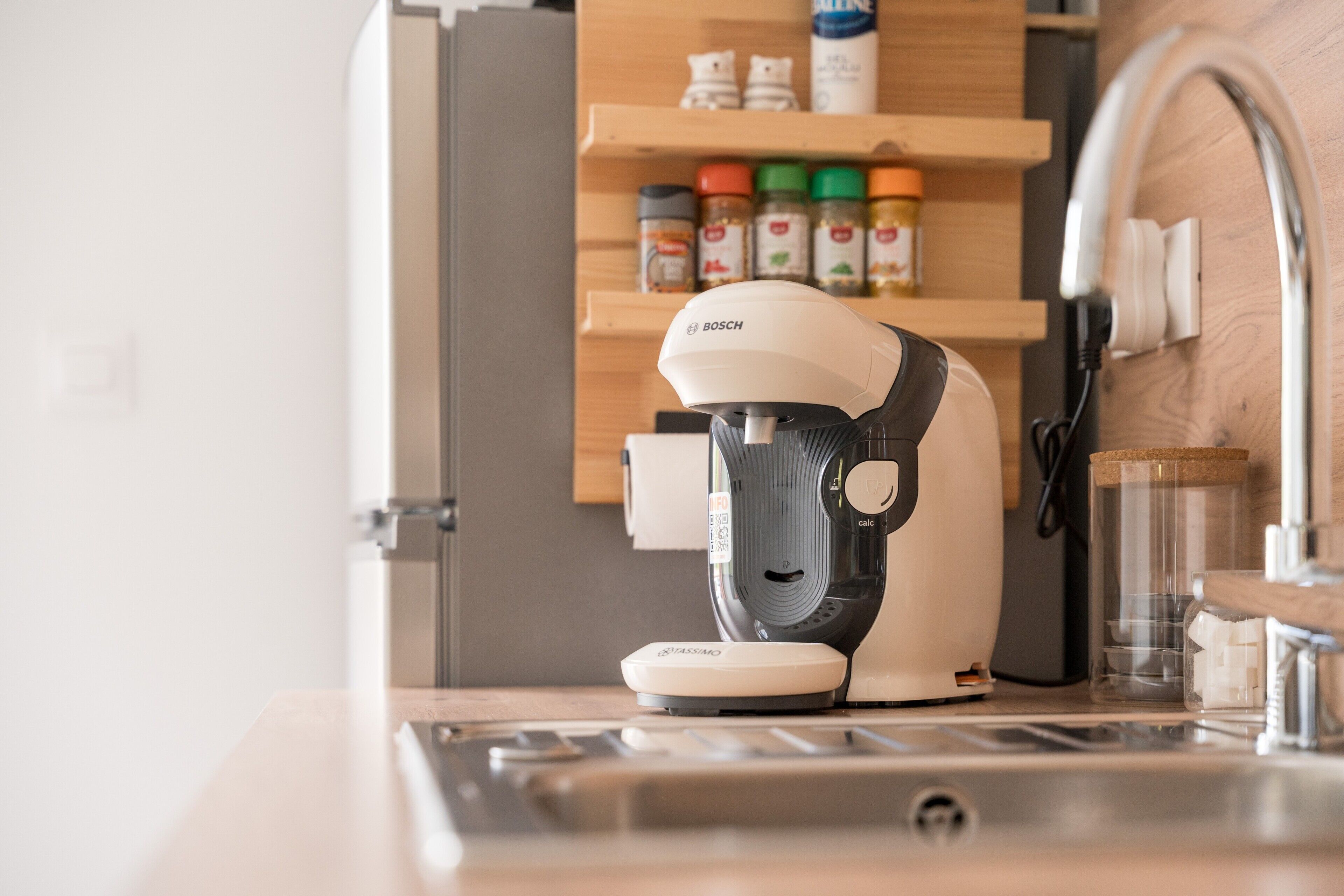 Eine Kaffeemaschine auf einer Küchenarbeitsplatte mit einem Holzboden im Hintergrund.