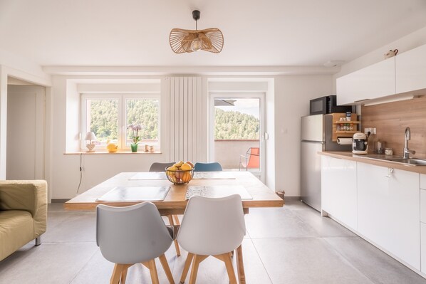 Una cocina moderna con comedor, ventanas amplias y vistas al exterior.